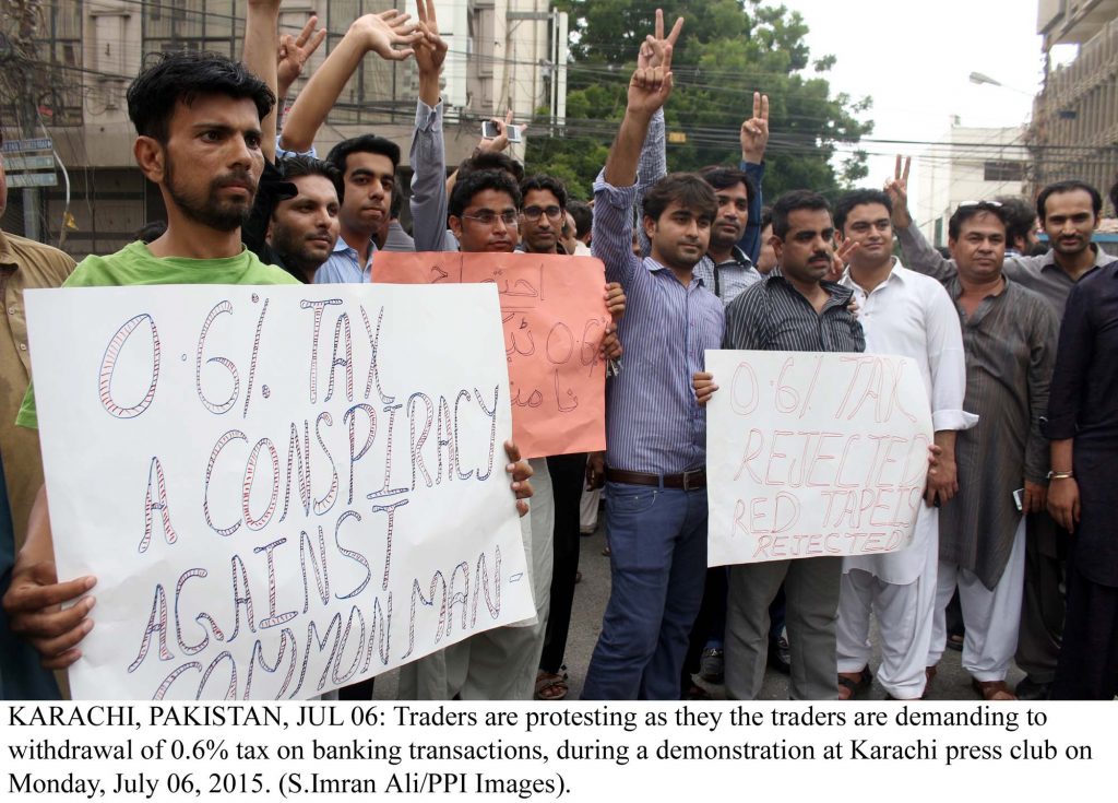 KARACHI, PAKISTAN, JUL 06: Traders are protesting as they the traders are demanding to  withdrawal of 0.6% tax on banking transactions, during a demonstration at Karachi press club on  Monday, July 06, 2015. (S.Imran Ali/PPI Images).